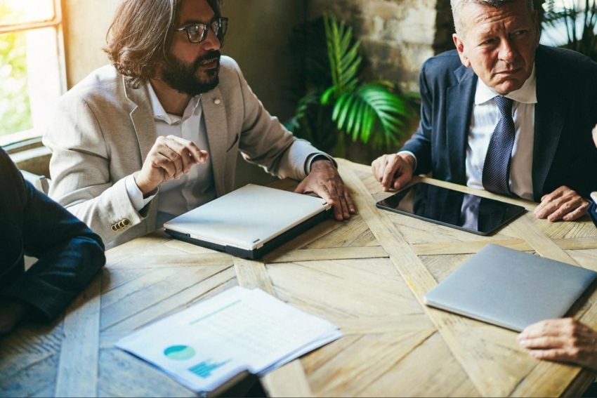 Two business leaders in a Dubai office discussing a candidate's competency assessment report